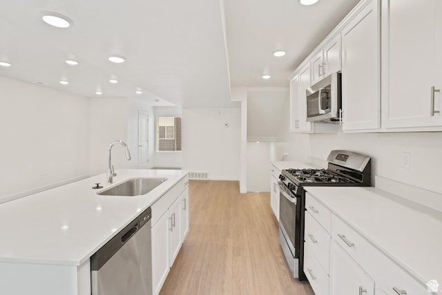67 E Hamblin Ln, Clearfield, UT 84015 - kitchen with stainless steel appliances, a sink, light wood-style floors, recessed lighting, and white cabinetry