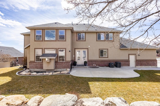 back of property featuring a yard, french doors, central AC, and stucco siding