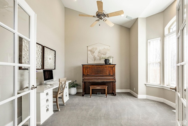office featuring a healthy amount of sunlight, high vaulted ceiling, and light carpet