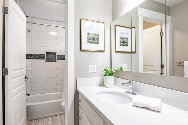 full bath with wood finished floors, vanity, shower / tub combination, and toilet