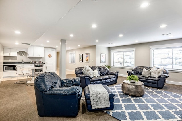 carpeted living room featuring baseboards, visible vents, and recessed lighting