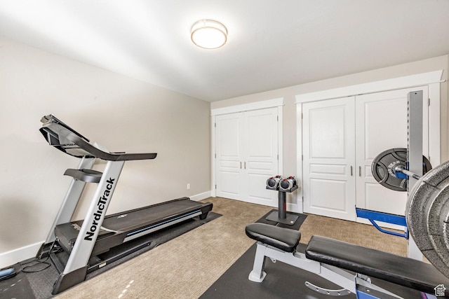 exercise room featuring baseboards and carpet flooring