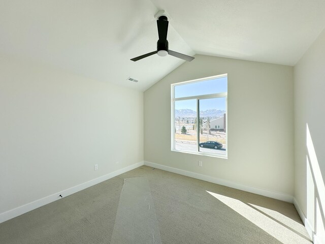 spare room with visible vents, baseboards, a ceiling fan, light carpet, and lofted ceiling