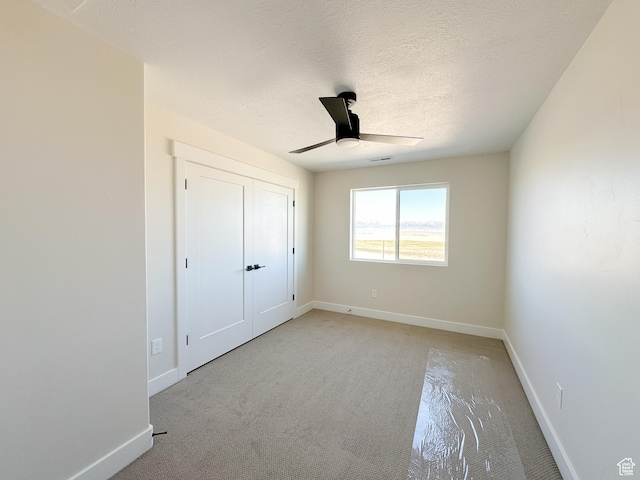 unfurnished bedroom featuring baseboards, a textured ceiling, visible vents, and ceiling fan