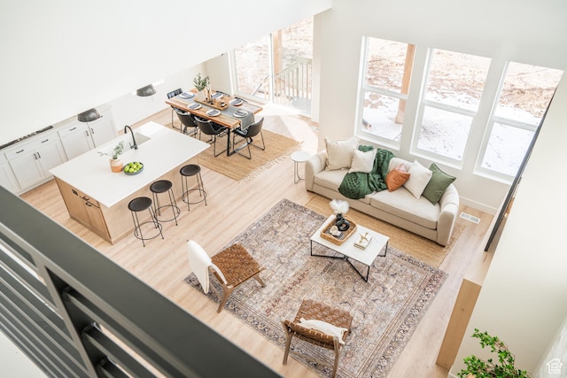 living area featuring visible vents, light wood-style flooring, and a wealth of natural light