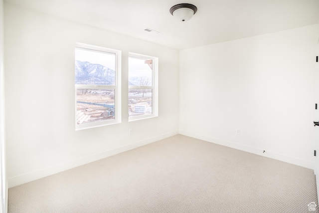 unfurnished room featuring light carpet, baseboards, and visible vents