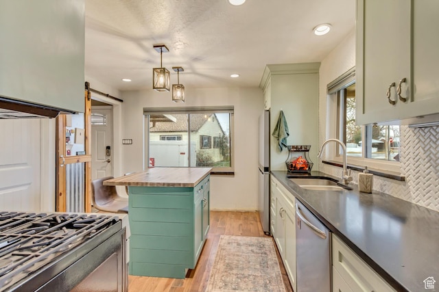 6259 S 340 E, Murray, UT 84107 - kitchen featuring wooden counters, a sink, stainless steel appliances, a barn door, and light wood-type flooring