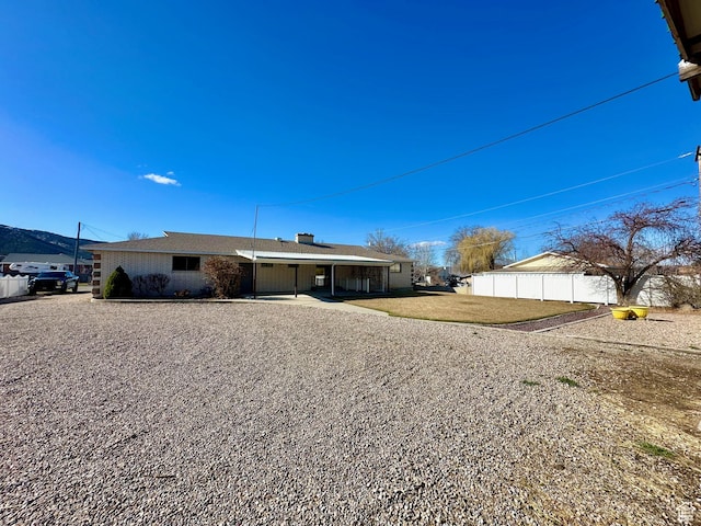 back of house with a lawn and fence