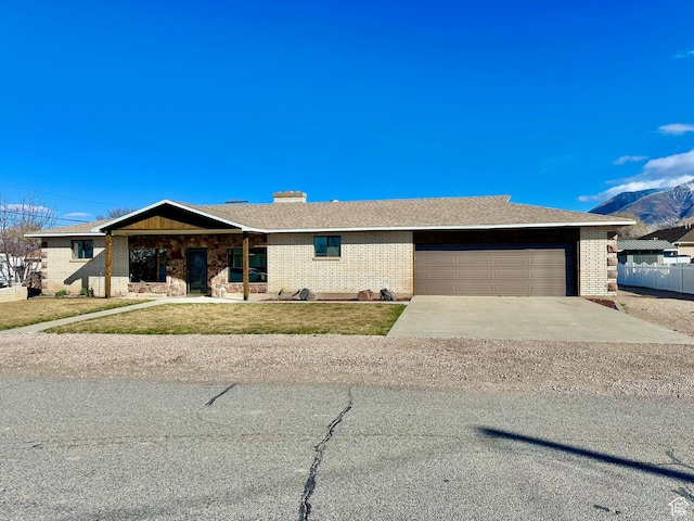 view of front facade with a front lawn, a garage, brick siding, and driveway