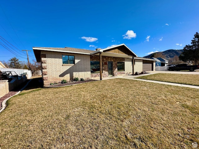 back of house featuring fence, a yard, concrete driveway, a garage, and brick siding