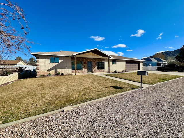 view of front of home with brick siding, a front lawn, fence, driveway, and an attached garage