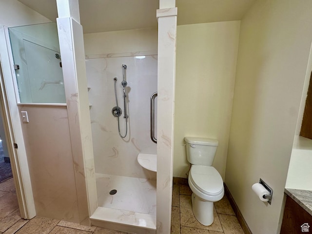 bathroom featuring baseboards, toilet, vanity, and walk in shower