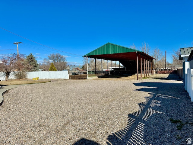 view of yard featuring a carport, fence, and driveway