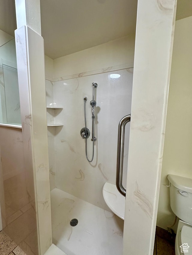 full bathroom with toilet and a stall shower