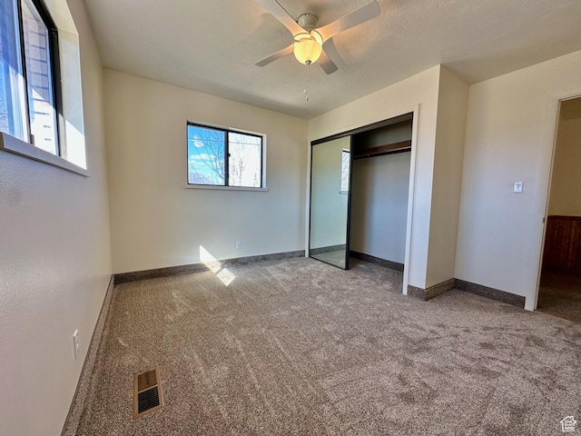 unfurnished bedroom featuring visible vents, baseboards, carpet floors, a closet, and a ceiling fan