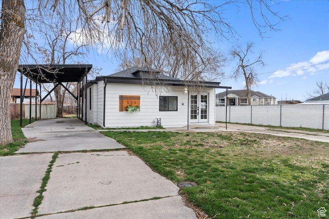 555 N 100 W, Tooele, UT 84074 - back of property featuring fence, driveway, a yard, a carport, and french doors
