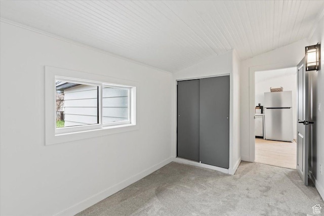 555 N 100 W, Tooele, UT 84074 - unfurnished bedroom with lofted ceiling, baseboards, freestanding refrigerator, and carpet floors
