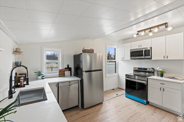 555 N 100 W, Tooele, UT 84074 - kitchen featuring light wood-type flooring, a sink, white cabinetry, appliances with stainless steel finishes, and light countertops