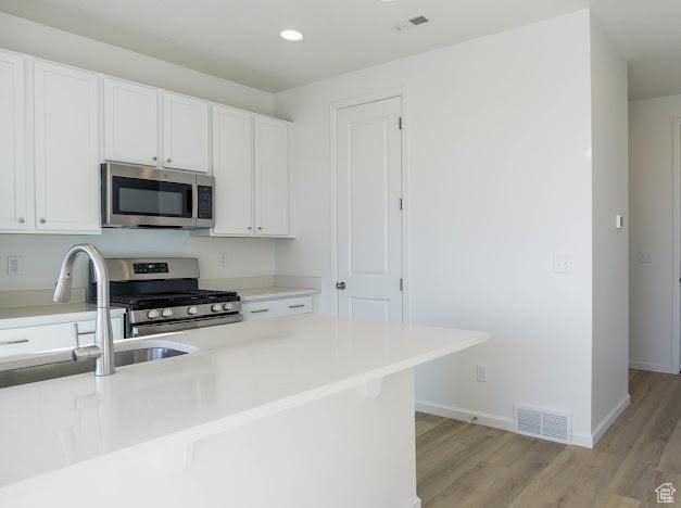 1114 W 450 S Unit 62, Brigham City, UT 84302 - kitchen featuring stainless steel appliances, light wood-type flooring, white cabinets, and recessed lighting
