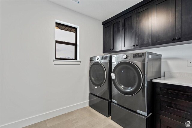 laundry area with baseboards, cabinet space, and washer and clothes dryer
