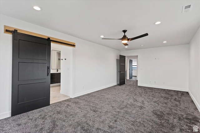 carpeted spare room with recessed lighting, visible vents, a barn door, and ceiling fan