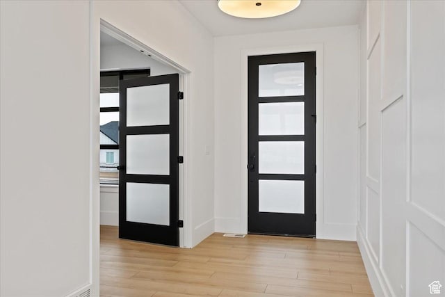 foyer featuring baseboards and light wood-style floors