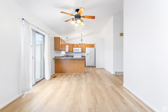 kitchen with visible vents, brown cabinets, white appliances, light wood-style floors, and a peninsula