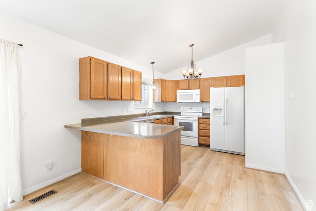 kitchen featuring visible vents, a notable chandelier, a sink, white appliances, and a peninsula