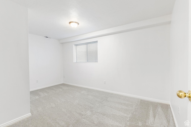 carpeted spare room with visible vents and baseboards