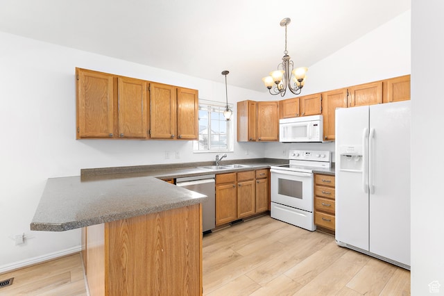 kitchen featuring white appliances, an inviting chandelier, light wood-style flooring, a peninsula, and a sink
