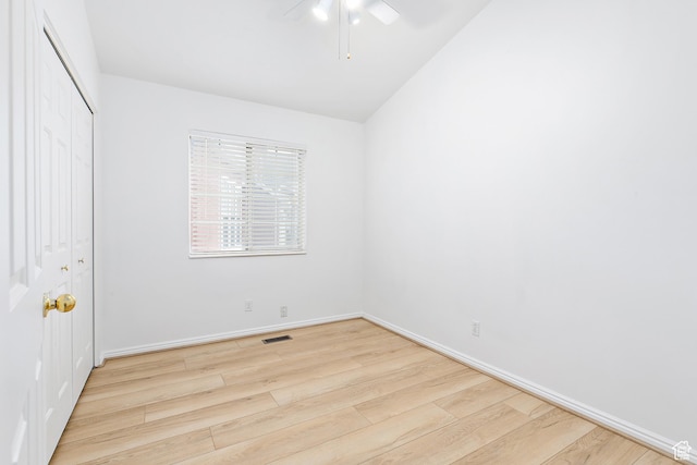 unfurnished bedroom with a ceiling fan, visible vents, wood finished floors, baseboards, and a closet