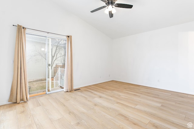spare room with visible vents, light wood finished floors, baseboards, ceiling fan, and vaulted ceiling