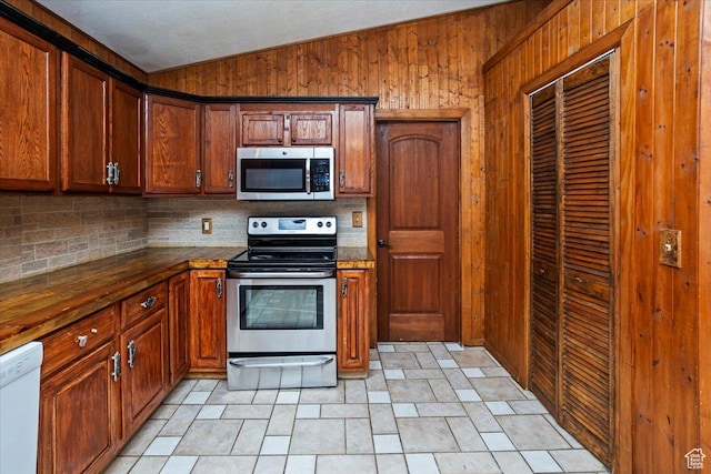 3356 W 1200 S, Ogden, UT 84404 - kitchen with backsplash, vaulted ceiling, appliances with stainless steel finishes, and wooden walls
