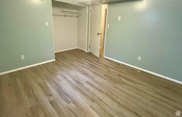unfurnished bedroom featuring a closet, baseboards, and wood finished floors
