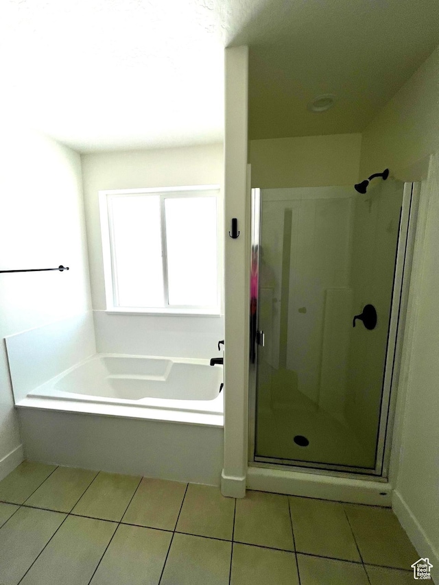 bathroom with tile patterned floors, a stall shower, and a bath