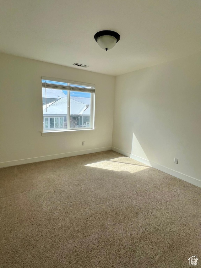 empty room with visible vents, baseboards, and carpet