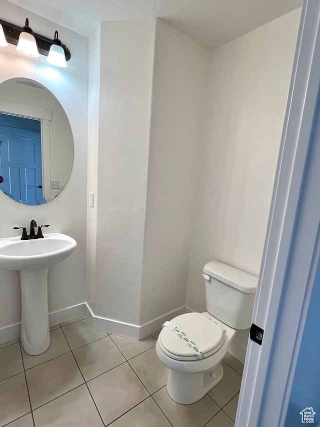 bathroom featuring tile patterned floors, toilet, and baseboards
