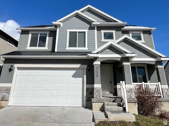 craftsman inspired home with driveway, a porch, stucco siding, a garage, and stone siding