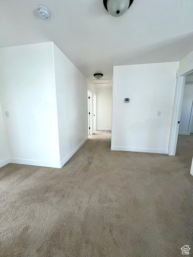 carpeted spare room featuring baseboards