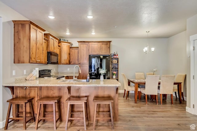 1128 S 820 E Unit 6104, Heber City, UT 84032 - kitchen with a kitchen bar, black appliances, a peninsula, and a sink