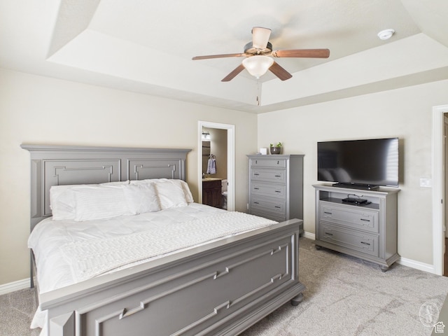 bedroom featuring ceiling fan, baseboards, light colored carpet, and a tray ceiling