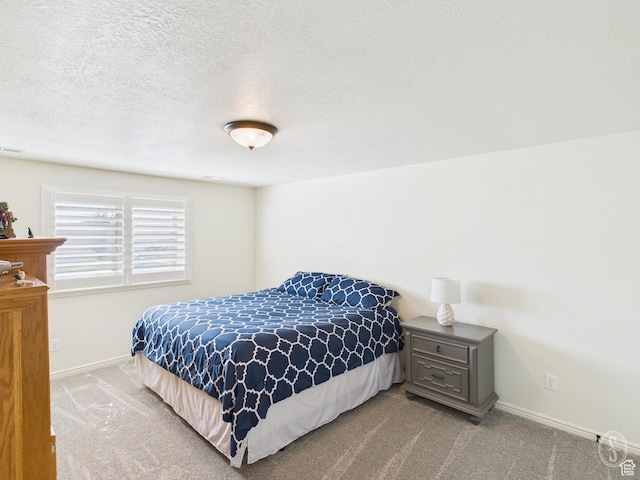 carpeted bedroom featuring baseboards and a textured ceiling
