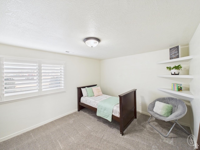 carpeted bedroom with baseboards, visible vents, and a textured ceiling