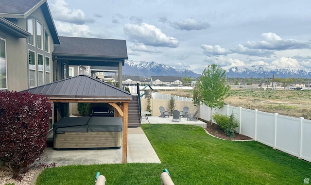 view of yard with a gazebo, a patio area, a hot tub, a mountain view, and a fenced backyard