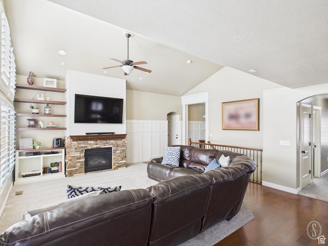 living room with arched walkways, ceiling fan, dark wood-style flooring, and vaulted ceiling