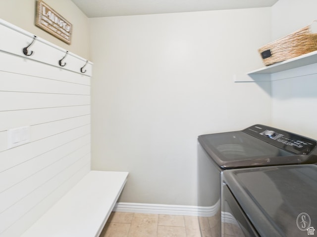 washroom featuring baseboards, washer and dryer, and laundry area