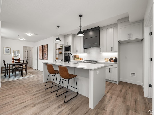 804 W 900 S, Springville, UT 84663 - kitchen featuring a sink, appliances with stainless steel finishes, light wood finished floors, custom exhaust hood, and light countertops