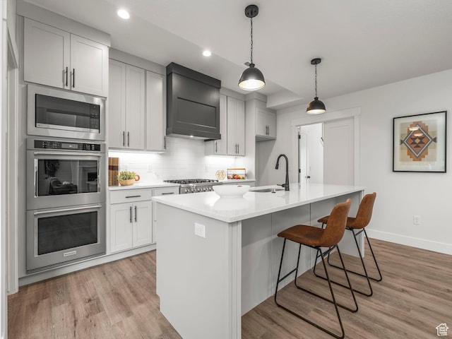 804 W 900 S, Springville, UT 84663 - kitchen with light wood finished floors, a sink, light countertops, appliances with stainless steel finishes, and wall chimney range hood