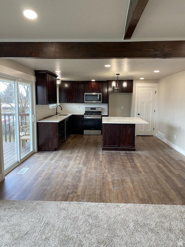 525 S 75 W, Providence, UT 84332 - kitchen featuring a center island, dark brown cabinetry, light countertops, beam ceiling, and stainless steel appliances