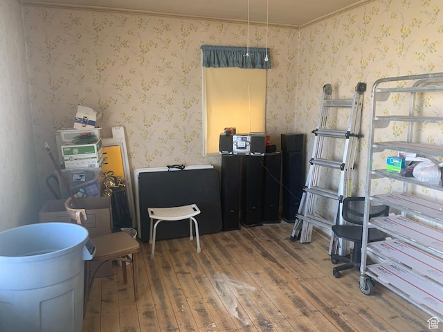 misc room featuring ornamental molding, wallpapered walls, and wood-type flooring